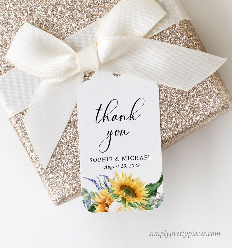 May include: White thank you tag with black calligraphy that says "thank you" and the text "Sophie & Michael August 20, 2022". The tag has a watercolor illustration of sunflowers, white roses, and greenery.