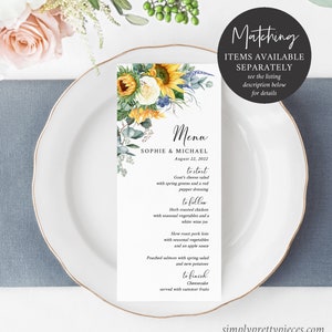 May include: A wedding menu card with a floral design featuring sunflowers, white roses, and eucalyptus leaves. The menu includes a goat cheese salad, herb roasted chicken, slow roast pork loin, poached salmon, and cheesecake. The card also includes the names Sophie & Michael and the date August 22, 2022.
