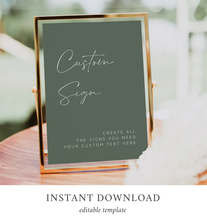 May include: A gold-framed sign with a sage green background. The sign says "Custom Sign" in white cursive writing. Below the text, it says "Create all the signs you need. Your custom text here."