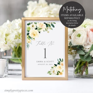 May include: White and yellow floral wedding table number card with a gold frame. The card says "Table No. 1" and "Emma & Scott August 20, 2021".