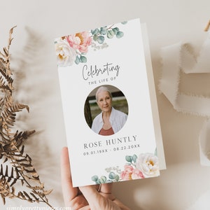 Puede incluir: Un programa fúnebre blanco con un diseño floral con flores rosas y blancas y hojas verdes. El texto "Celebrando la vida de" está en la parte superior del programa, seguido de una foto de una mujer y el nombre "Rose Huntly" con las fechas "09.01.19XX - 08.22.20XX".