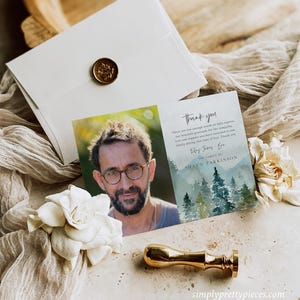 May include: Thank you card with a watercolor illustration of a forest and a photo of a man wearing glasses. The text on the card reads "Thank you. There are not enough words to fully express our heartfelt gratitude for the sympathy, love and support you have extended to our family during this time of loss. Thank you."  The family of Shaun Parkinson.