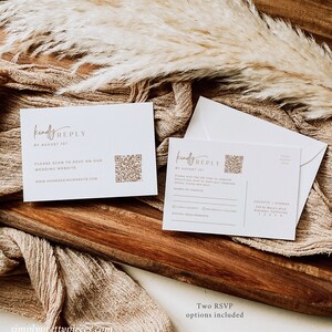May include: Two white RSVP cards with a gold script font. The top card says "Kindly Reply by August 1st" and has a QR code. The bottom card has a QR code and a section for guests to RSVP with their names and dietary requirements. The text "Juliette + Thomas 123 St. Mary's Blvd. Anytown, California 12345" is printed on the bottom card.