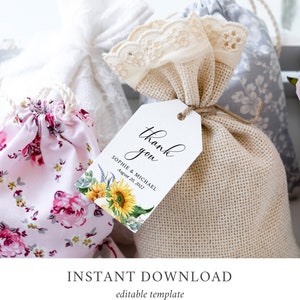 May include: White thank you tag with black calligraphy that says "Thank you" and the text "Sophie & Michael August 20, 2022". The tag has a watercolor illustration of sunflowers and greenery.