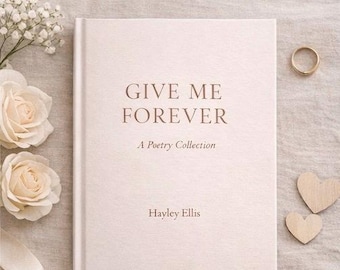 May include: A light pink hardcover book titled "GIVE ME FOREVER", subtitled "A Poetry Collection" by Hayley Ellis. The image also features a gold ring, two wooden hearts, and cream-coloured roses, all arranged on a neutral surface.