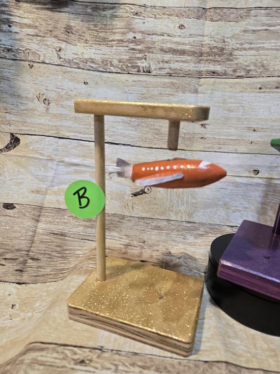 A tiny handmade wooden figure — kite, fish, or plane — that floats magically above your desk using hidden magnets, zero batteries required.