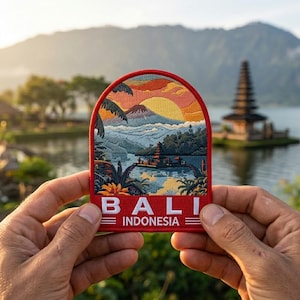 May include: A red-bordered patch featuring a detailed embroidered landscape of Bali, Indonesia. The design includes a sunset, mountains, a lake, and a temple. The word "BALI" and "INDONESIA" are displayed in white text.
