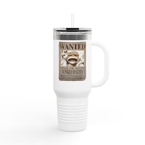 May include: White travel mug with a handle and a straw. The mug features a "Wanted" poster design with the character Monkey D. Luffy from the anime series One Piece. The poster includes the text "Dead or Alive" and a bounty amount.