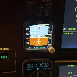 Könnte beinhalten: Ein Flugzeugcockpit-Instrumentenbrett mit einem primären Flugdisplay, das einen künstlichen Horizont in Blau und Braun, Geschwindigkeitsanzeigen und einen Luftdruckwert von 1019/30.09 zeigt. Darunter befindet sich eine Navigationsanzeige für DME-L und DME-R.
