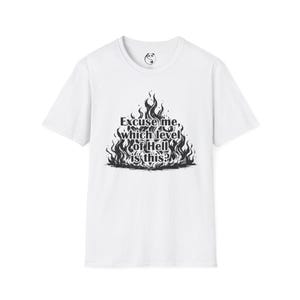 Puede incluir: Camiseta blanca con un gráfico negro de llamas y el texto "Excuse me, which level of Hell is this?" La camiseta tiene cuello redondo y mangas cortas. Un logo de panda está en la parte superior de la espalda.