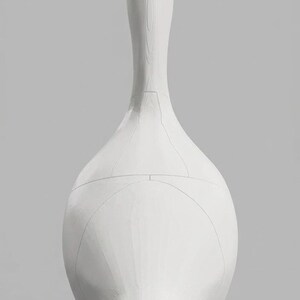 May include: A white goose sculpture with orange feet. The sculpture has a long neck and a rounded body. The design includes visible seam lines. The background is a solid gray.