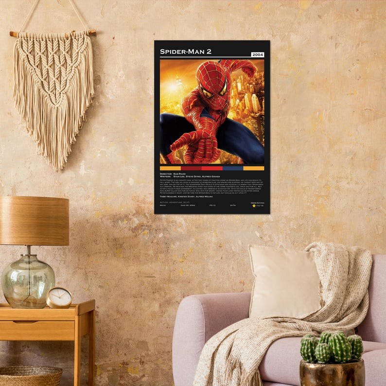 May include: A framed poster of the movie "Spider-Man 2" from 2004. The poster features Spider-Man in his red and blue suit, with a cityscape in the background. The poster has a black border and includes the movie title and credits.
