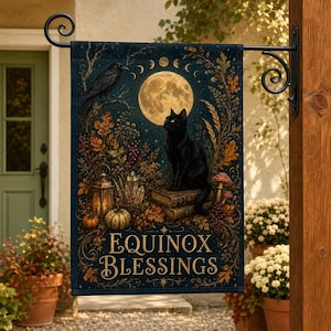 May include: A rectangular garden flag featuring a black cat sitting on books under a full moon and lunar phases. The design includes a raven, autumn foliage, a lantern, crystals, and mushrooms. The text reads EQUINOX BLESSINGS in gold lettering.