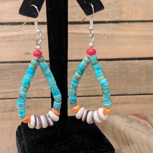 May include: Turquoise and white beaded earrings with silver hooks. The earrings have a triangular shape, with turquoise beads forming the main body, accented by red and orange beads.