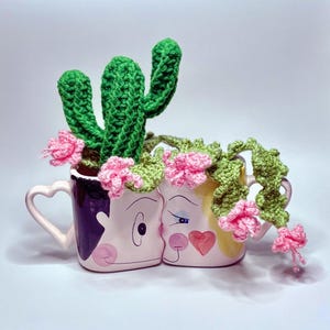 以下が含まれることがあります： 黒い持ち手と「But First, Coffee」の文字が黒い手書き風フォントで書かれた白いセラミックマグ。マグカップは白い表面に置かれています。