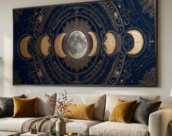 May include: A large, framed wall art piece featuring a celestial design. The artwork showcases the phases of the moon in gold against a dark blue background. The central moon is a detailed, realistic depiction. The piece is displayed above a sofa with gold and gray pillows.