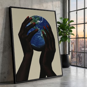 Può includere: Stampa artistica incorniciata con mani scure con smalto rosso che tengono un globo blu e verde. L'opera d'arte è ambientata su uno sfondo neutro, con una cornice nera. L'immagine è esposta in un interno moderno.