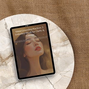 May include: A digital tablet showing the text "Vision Grounding Practices: 3 Embodied Rituals for Clarity & Courage" and an illustration of a woman. The tablet is on a marble-effect surface, set against a burlap backdrop.