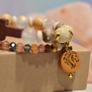 Pode incluir: Uma caneca de cer&acirc;mica branca com uma al&ccedil;a preta e o texto "But First, Coffee" em negrito preto. A caneca est&aacute; sobre um fundo desfocado, sugerindo um ambiente acolhedor.