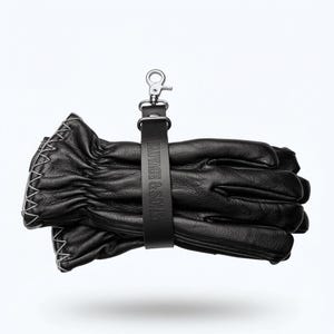 以下が含まれることがあります： 白いステッチと黒い革ストラップが付いた黒い革手袋。 ストラップには「SAVAGE & SONS」のエンボス加工が施されており、シルバーカラーの金属クリップに取り付けられています。
