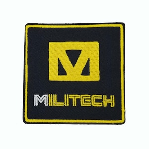 May include: A square embroidered patch with a black background and a yellow border. The center features a yellow stylized letter M icon above the white and yellow text MILITECH. The design is stitched with a visible fabric texture throughout.