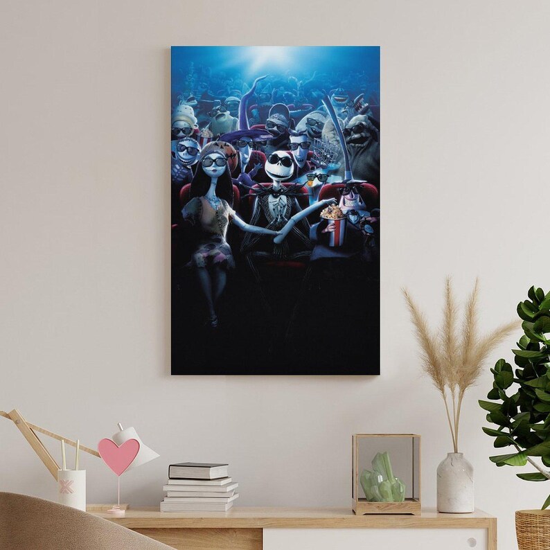 Puede incluir: Impresi&oacute;n en lienzo enmarcada que presenta una escena de Pesadilla antes de Navidad. Jack Skellington y Sally est&aacute;n sentados en un cine, rodeados de otros personajes. La obra de arte tiene un ambiente oscuro y cinematogr&aacute;fico.