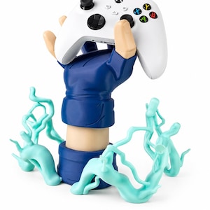May include: A white wireless video game controller held aloft by a sculpted hand wearing a blue glove. The base of the stand features light blue, swirling energy-like effects that extend outward from the wrist, creating a dynamic display.
