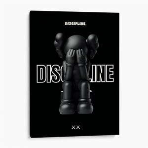 Op de afbeelding: Een zwart canvas wandkunstwerk met een matzwart figuur dat zit met de handen voor het gezicht. Het woord DISCIPLINE staat in het wit bovenaan en in grote wit omrande letters achter het figuur. Onderaan staan twee witte X-symbolen afgebeeld.