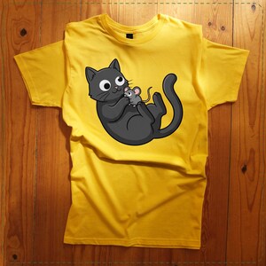 May include: Yellow t-shirt featuring a cartoon cat holding a mouse. The cat is black with white eyes and a gray outline. The mouse is gray. The t-shirt is made of a soft material and is suitable for casual wear.