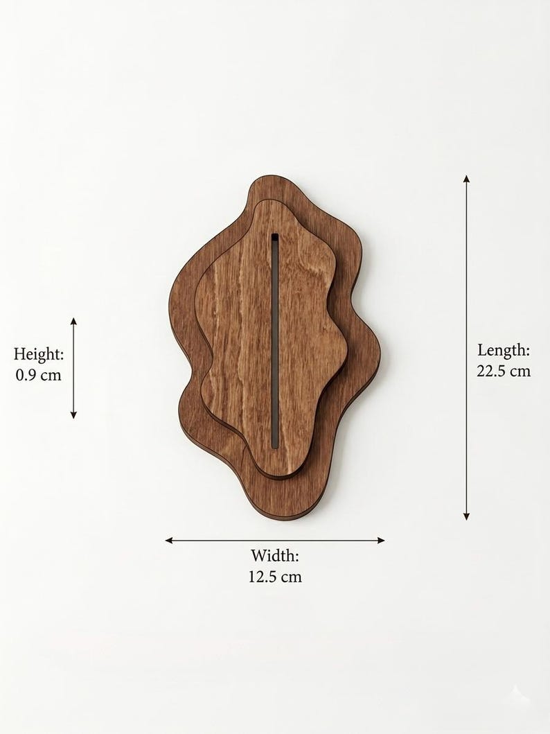 May include: A layered wooden display stand with an irregular, organic shape and a central vertical slot. The object measures 22.5 cm in length, 12.5 cm in width, and 0.9 cm in height, as indicated by the text labels and arrows in the image.