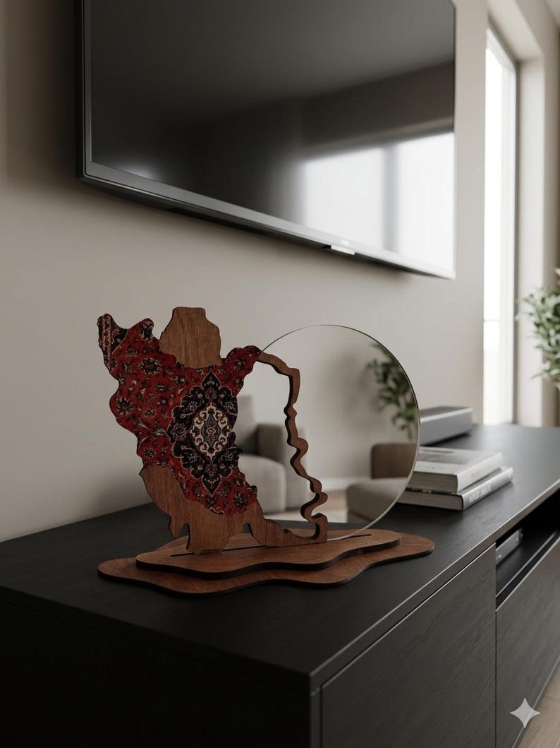 May include: A decorative wooden sculpture featuring a cutout of the state of Wisconsin, with a red and black patterned inlay on the left side and a circular mirror attached to the right, all mounted on a layered, irregular wooden base.