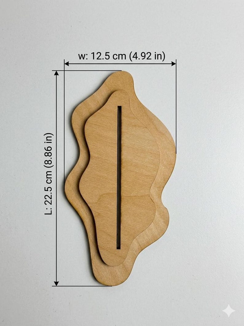 May include: A light brown wooden display stand with an organic, wavy shape and a central vertical slot. The stand measures 4.92 inches in width and 8.86 inches in length, as indicated by the text and dimension lines visible on the image.