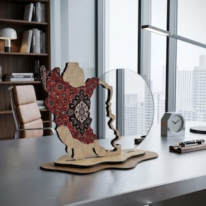 May include: A decorative wooden sculpture featuring a cutout map shape with a detailed red and black floral pattern on one side, mounted on a layered wooden base next to a circular clear acrylic panel, creating a layered display piece.
