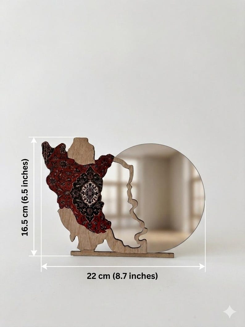 May include: A wooden decorative object featuring a circular mirror attached to a cutout shape with a red and black intricate patterned overlay. The item measures 16.5 cm (6.5 inches) in height and 22 cm (8.7 inches) in width as indicated by labels.