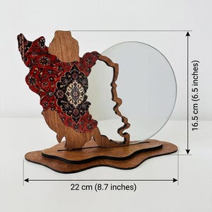 May include: A decorative wooden stand featuring a red and black patterned inlay on one side and a circular mirror on the other, mounted on a layered base. The object measures 6.5 inches in height and 8.7 inches in width as indicated by labels.