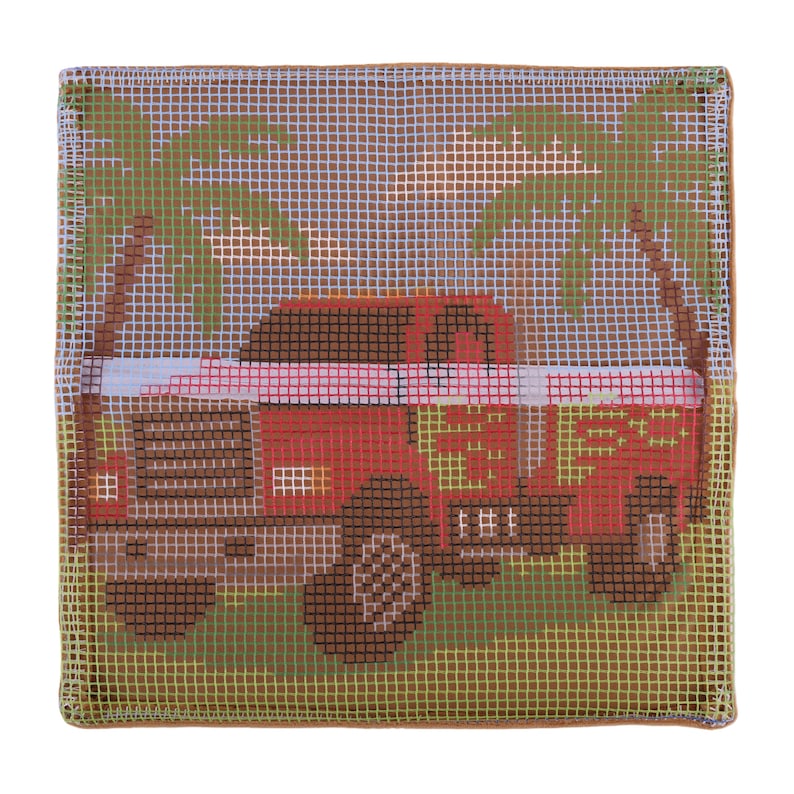 May include: A square needlepoint canvas featuring a red truck with brown wheels and a brown cab. The scene includes green palm trees against a light blue sky. The design is printed on a white grid mesh fabric with a finished brown edge border.