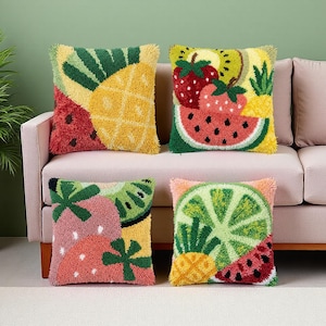Peut inclure: Quatre coussins carrés avec des motifs de fruits. Chaque coussin présente un fruit différent : ananas, pastèque, fraises, kiwi et citron vert. Les coussins ont un aspect texturé et touffeté avec des couleurs variées, dont le jaune, le vert, le rouge et le rose.