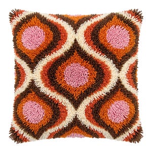 May include: A square throw pillow featuring a shaggy, tufted texture with a repeating geometric pattern. The design consists of concentric diamond shapes in shades of pink, orange, dark brown, and cream, creating a dense, multi-layered surface.