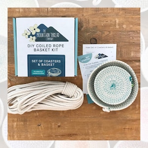 May include: A DIY coiled rope basket kit from The Mountain Thread Company. The kit includes a box, rope, instructions, and a set of coasters and a basket. The box reads "DIY Coiled Rope Basket Kit" and "Set of Coasters & Basket". The coasters and basket are white and teal.