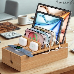 May include: A bamboo charging station with multiple slots for smartphones, tablets, smartwatches, and wireless earbuds. Devices are shown charging with white cables. A blue smartwatch and white earbuds are also visible. The brand name "NumaLivingCo" is in the top right corner.