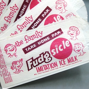 May include: A stack of vintage Fudgsicle ice milk bags. The bags are white with red text and illustrations, including the words "Fudgsicle" and "Take Home Pak". The bags feature cartoon characters and the text "the family".