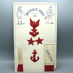May include: Vintage "Middy Set Combination" with red embroidered nautical emblems, including an eagle, anchors, and stars. Includes red ribbon and braid. The "Middy Lace" ribbon is 27 inches long.