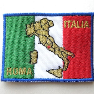 May include: Embroidered patch featuring the Italian flag design. The patch has a green, white, and red color scheme, with a gold-colored map of Italy. The words "ROMA" and "ITALIA" are embroidered in gold. The patch is bordered with blue.