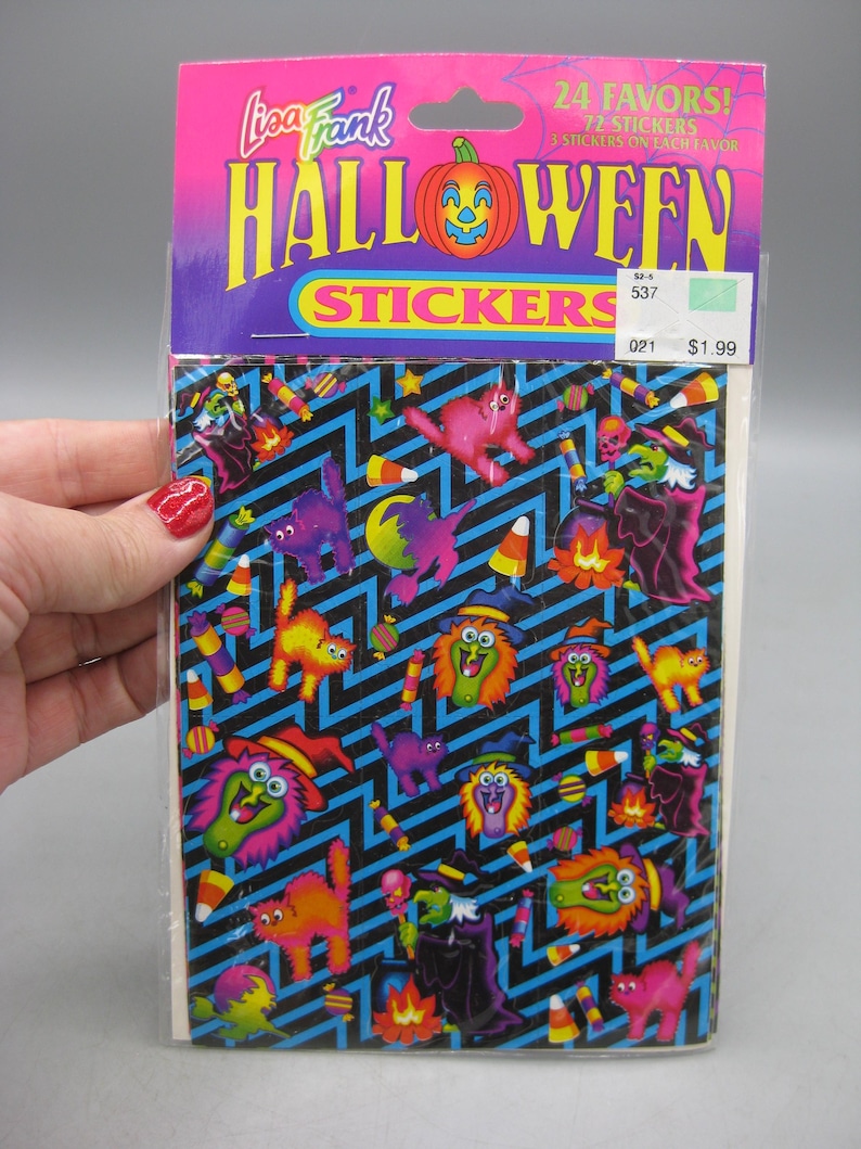 Puede incluir: Un paquete de pegatinas de Halloween de Lisa Frank. El paquete tiene una parte superior rosa y morada con las palabras "Halloween Stickers" y una calabaza. Las pegatinas presentan gatos de dibujos animados, brujas y caramelos de ma&iacute;z sobre un fondo en zigzag negro y azul.