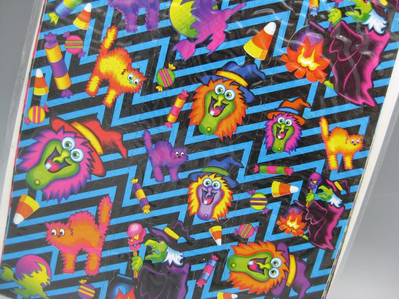 Puede incluir: Una hoja de pegatinas con tem&aacute;tica de Halloween con un patr&oacute;n de zigzag negro y azul. Las pegatinas presentan brujas de dibujos animados, gatos, caramelos de ma&iacute;z y otros elementos festivos en colores vibrantes.