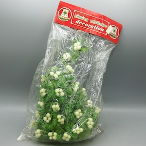 May include: A kissing mistletoe decoration in a clear plastic bag with a red header card featuring the text kissing mistletoe decoration. The item consists of green plastic foliage with clusters of small, round, off-white berries throughout.