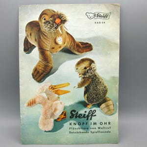 May include: Vintage Steiff catalog featuring plush animal toys. The cover displays a brown walrus, a small beaver, and a pink pelican. The catalog has the Steiff logo and text in German.