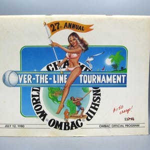 May include: A vintage 1980 Over-the-Line Tournament program featuring a graphic illustration of a person in a bikini holding a flag, a baseball, a globe, and a batter. The text reads 27th Annual Over-the-Line Tournament, World Championship, Ombac, and July 12, 1980.