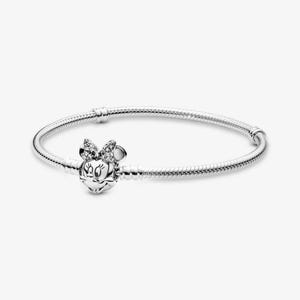 Peut inclure: Un bracelet en chaîne serpent argentée doté d'un fermoir en forme de tête de souris de dessin animé avec un nœud. Le nœud est orné de petites pierres claires et scintillantes. Le bracelet présente une texture métallique souple et lisse.