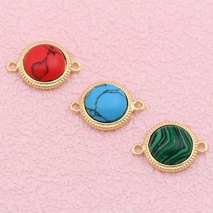 May include: Three round gemstone connectors in red, turquoise, and green, each set in a gold-colored bezel with a beaded edge. The connectors have small loops on either side for attaching to other components.